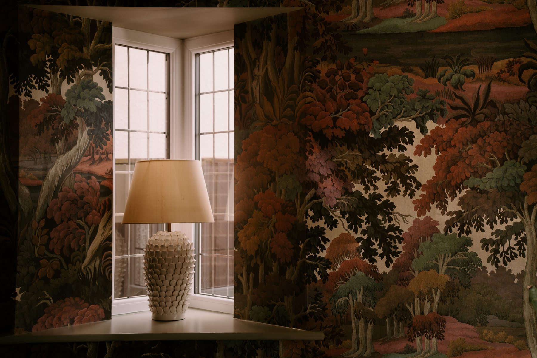 Lamp and mural-style wallpaper in the lounge