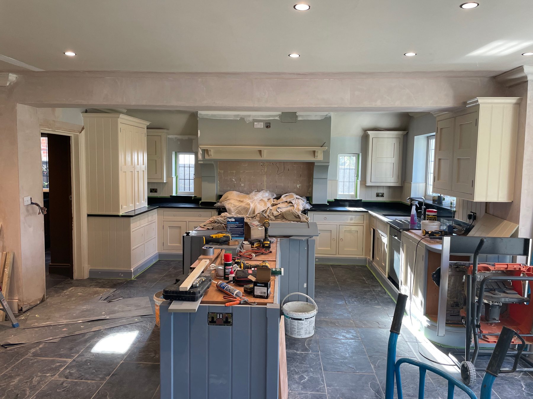 Dark kitchen cabinetry being installed