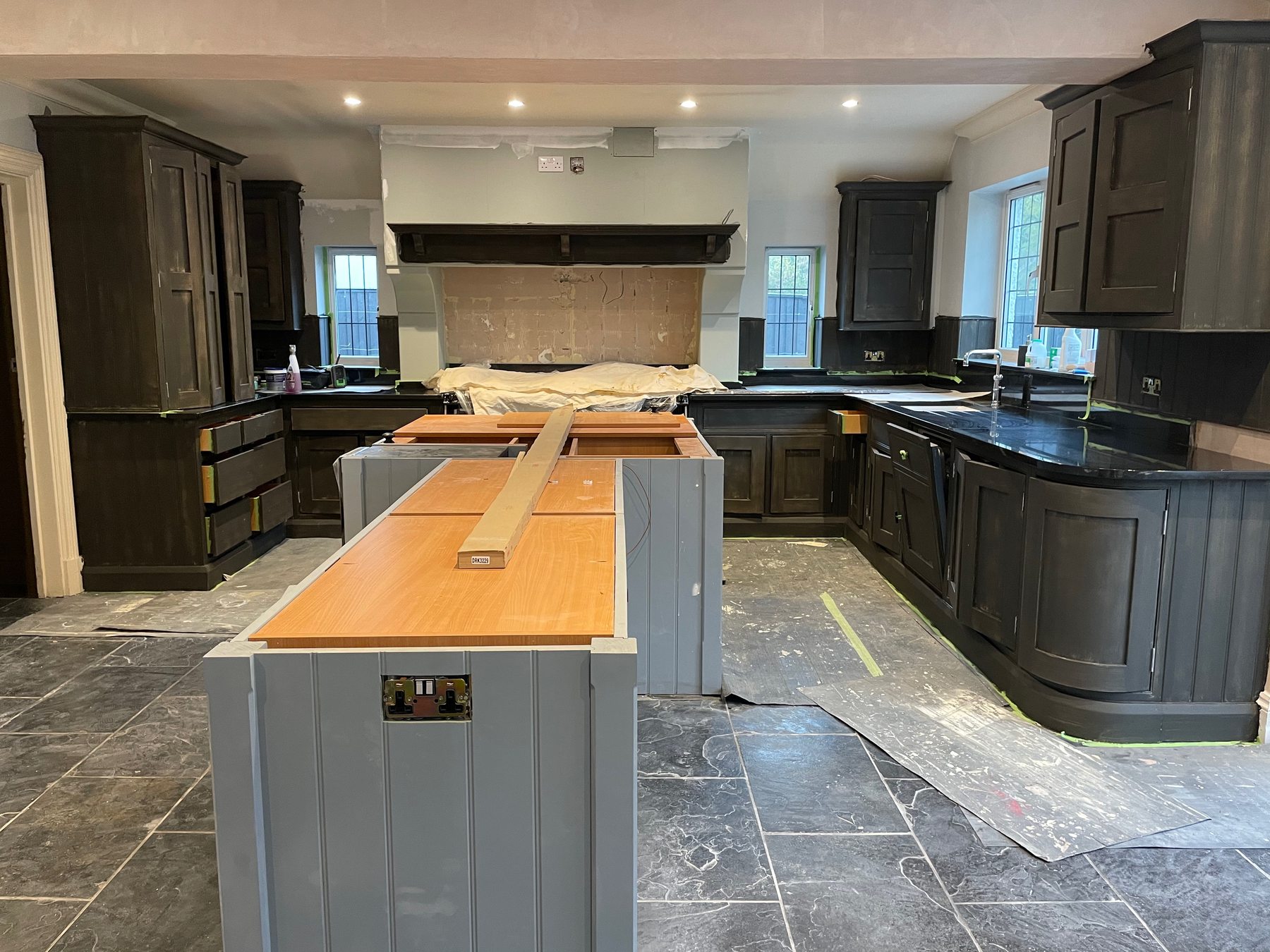 The nearly finished dark kitchen with timber island worktop